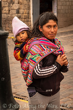 Woman Carrying Child at Bus Stop (Peru)
